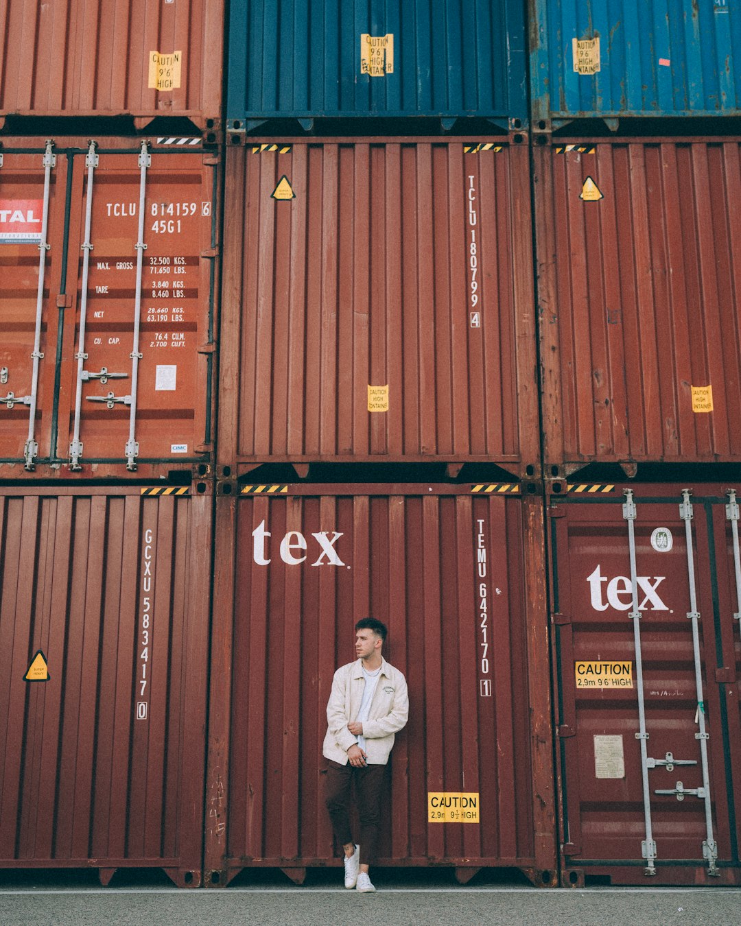 services-01 a-man-standing-in-front-of-a-stack-of-shipping-containers-nvinwsgsxj0